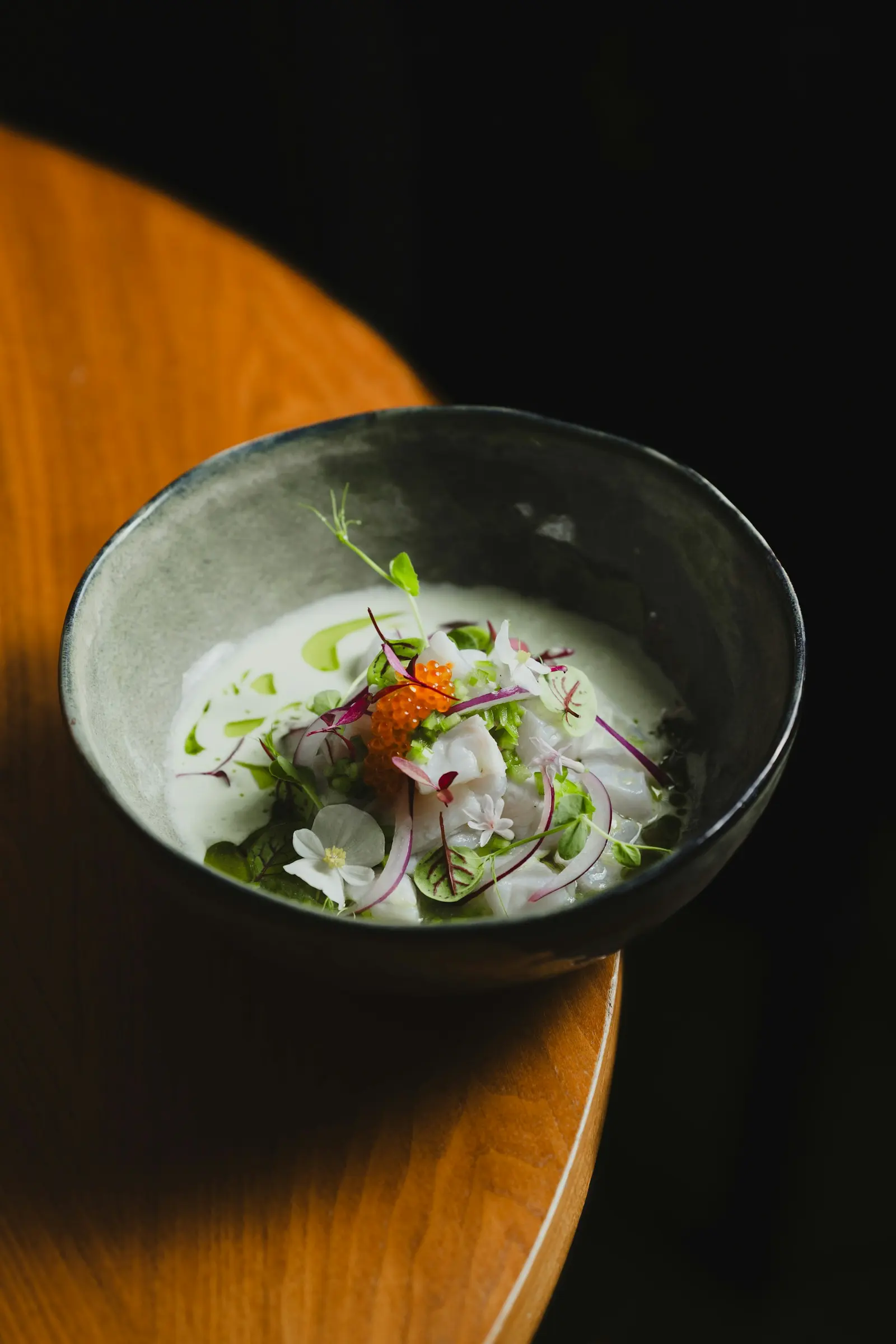 Ceviche de estilo nikkei sobre fondo oscuro