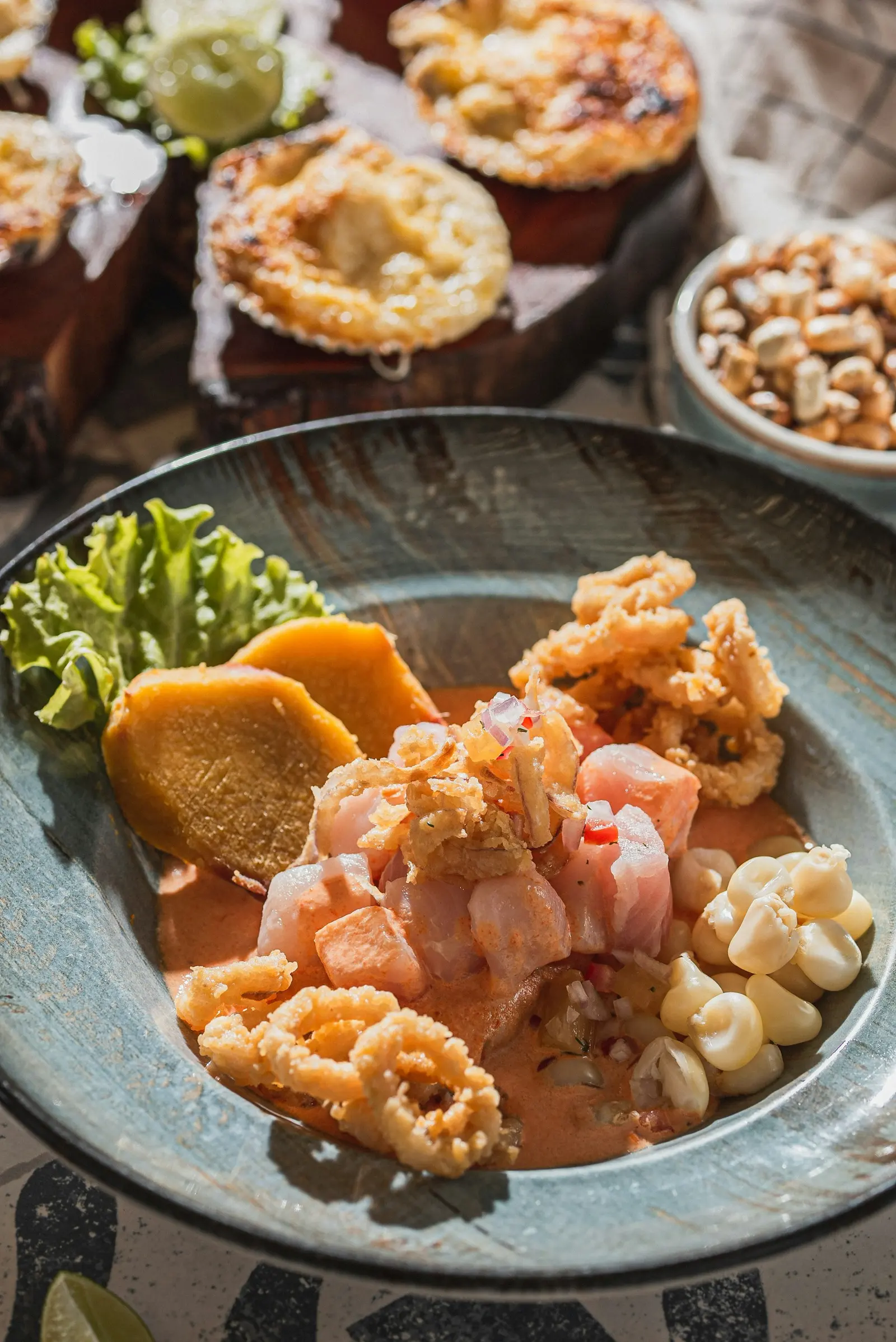 Ceviche con leche de tigre de ají amarillo, camote, choclo, cancha y chicharrón de calamar